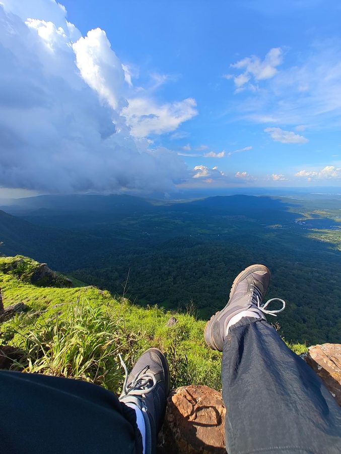 Resting at a green mountain summit overlooking a valley